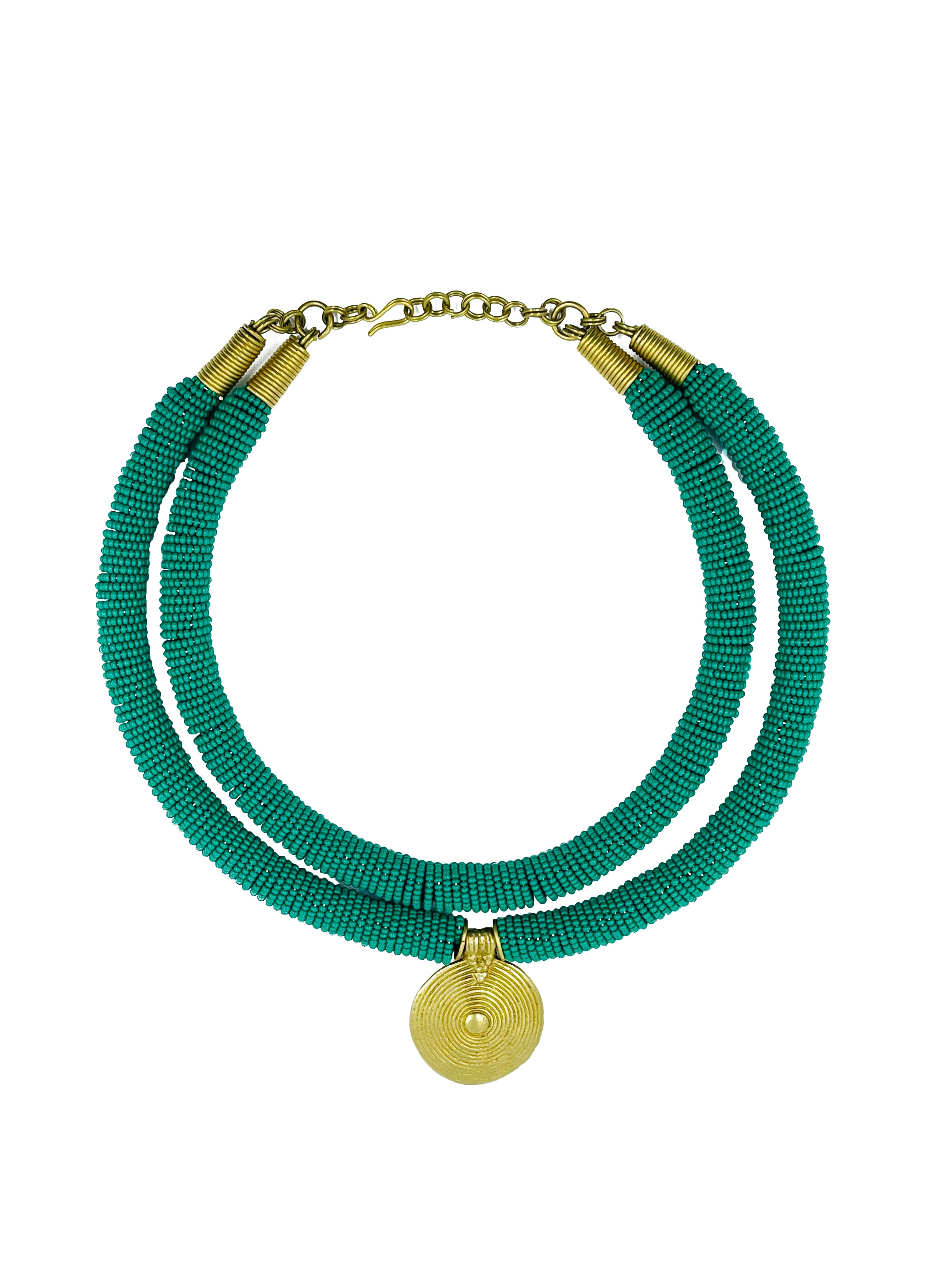 Aje is a stunning necklace showcasing African artistry's essence. The necklace features an eight-inch strand of handcrafted glass beads sourced locally in Africa