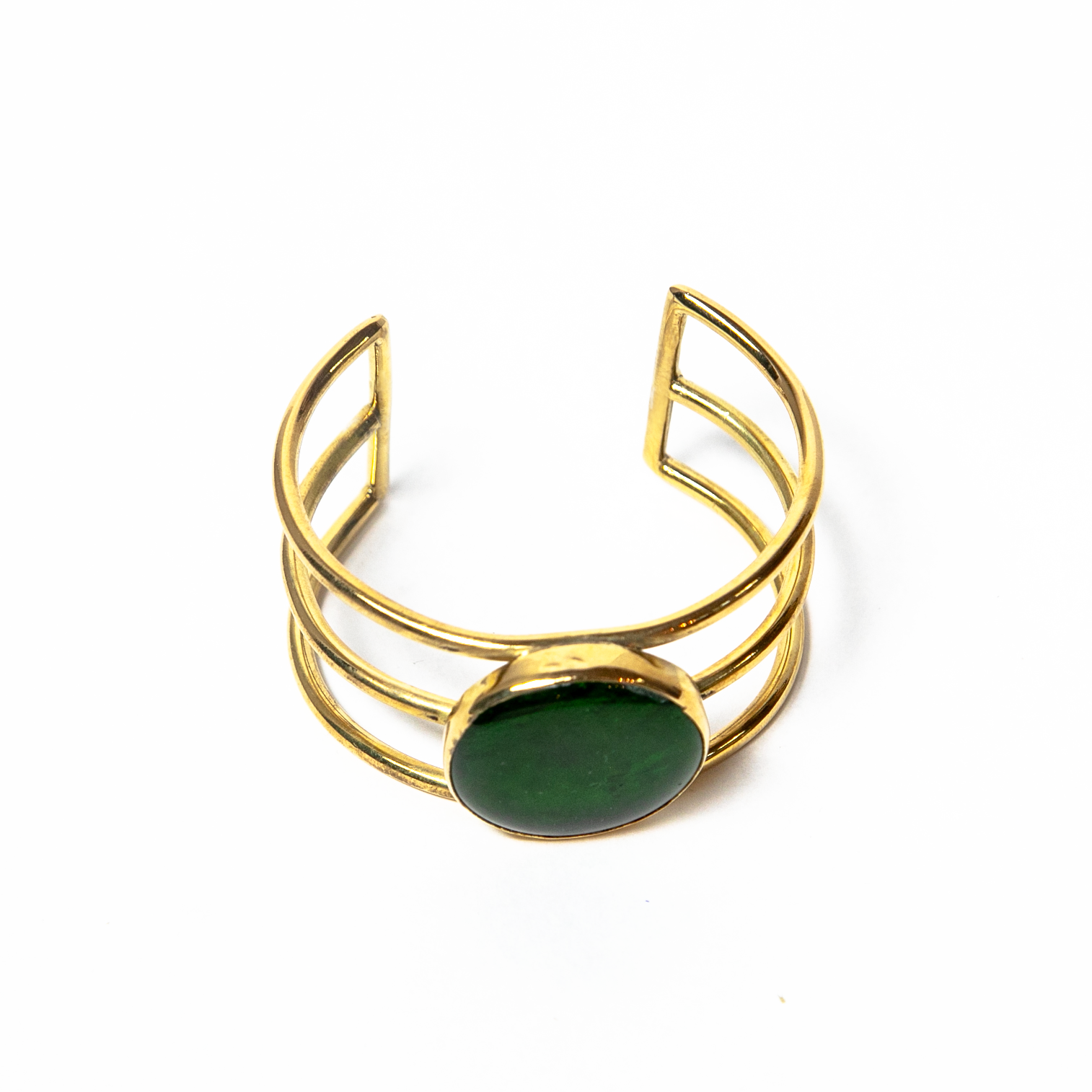 A beautifully handcrafted gold-toned cuff bracelet with a green glass stone in the center. Versatile and easy to wear from day to night.