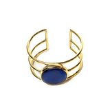 A beautifully handcrafted gold-toned cuff bracelet with a blue glass stone in the center. Versatile and easy to wear from day to night.