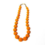 Handcrafted beaded ball necklace featuring vibrant orange beads and gold-toned accents, elegantly designed for a stylish and unique look.